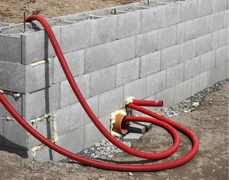 Základová zeď z bloků s vývodem pro odvodňovací trubici.