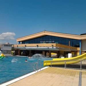 Vnější pohled na aquapark v Hustopěci s bazénem a skluzavkou.