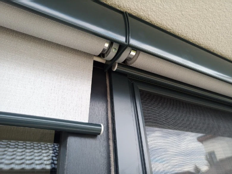 Detail venkovní rolety pro zastínění balkónu s tmavým rámem.