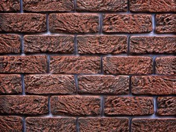 Detailní pohled na cihlovou stěnu s viditelnými švy.