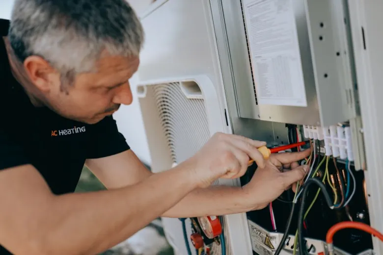 Technik opravuje elektrické součásti tepelného čerpadla vzduch-vzduch.