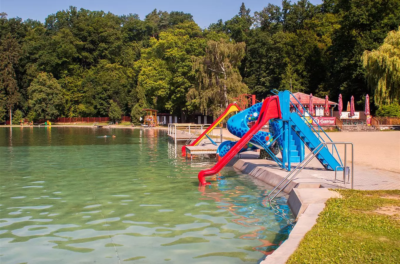 Koupaliště v Rokycanech s barevnými vodními skluzavkami.