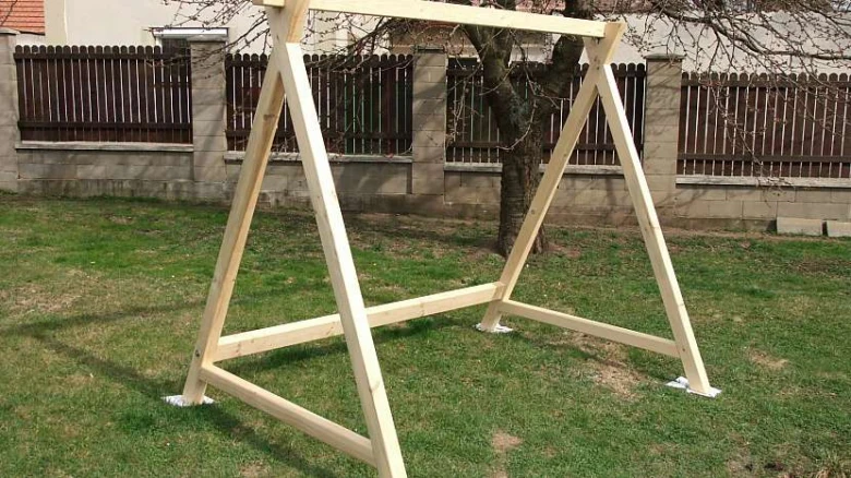Nově postavená dřevěná houpačka na trávníku.