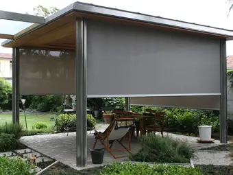 Moderní pergola s roletami pro zahradní stínění.