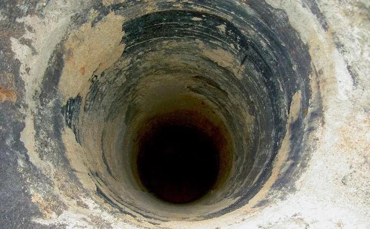 Vnitřek betonové technické šachty s viditelnou korozí.