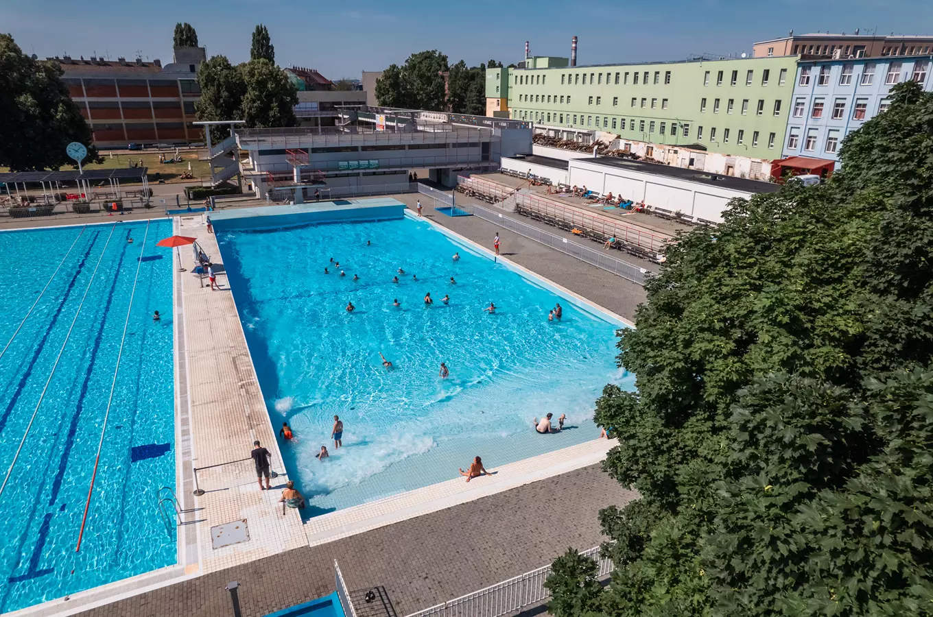 Venkovní plavecký bazén v Zábřově s lidmi ve vodě.