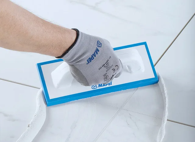 Ručník s hřebenem pro nanášení hydroizolace na dlažbu v koupelně.