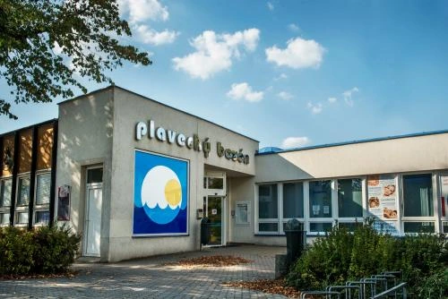 Vnější pohled na plavecký bazén v Českém Třebovém pod modrou oblohou.