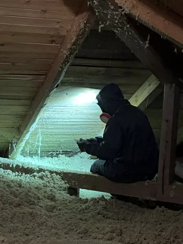 Osoba aplikuje čedičovou izolaci do střešního prostoru.