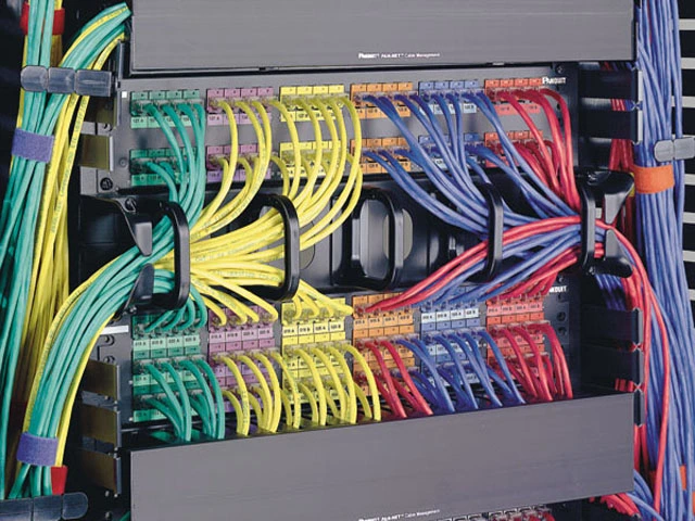 Organizace síťových kabelů v rozvaděči pro domácí internet.