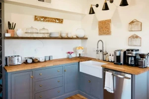 Modrá kuchyňská linka s dřevěnými pracovními deskami ve stylu provence.