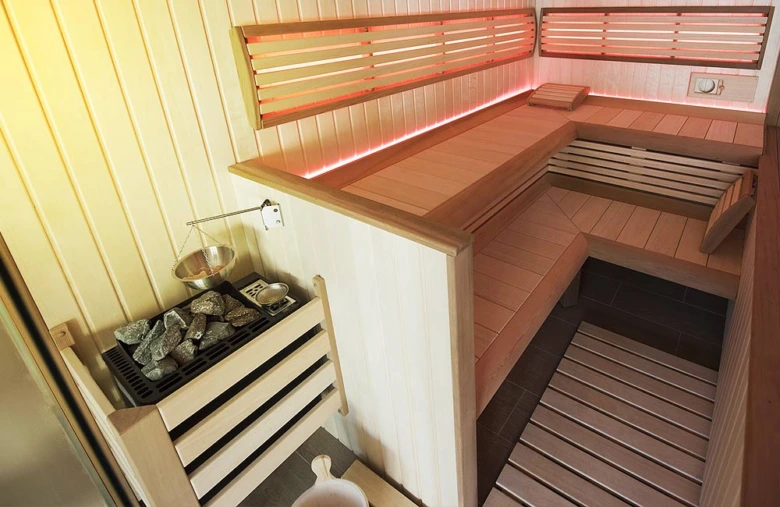 Sauna s kamny na topení v dřevěném interiéru