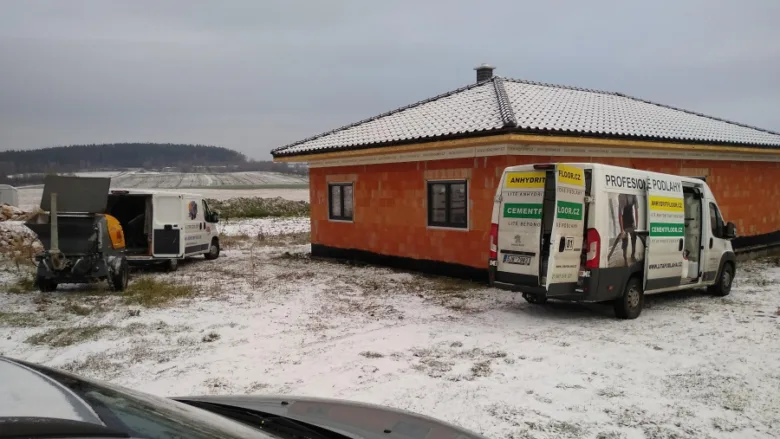 Práce na stavbě s dodávkou betonu v zimě.