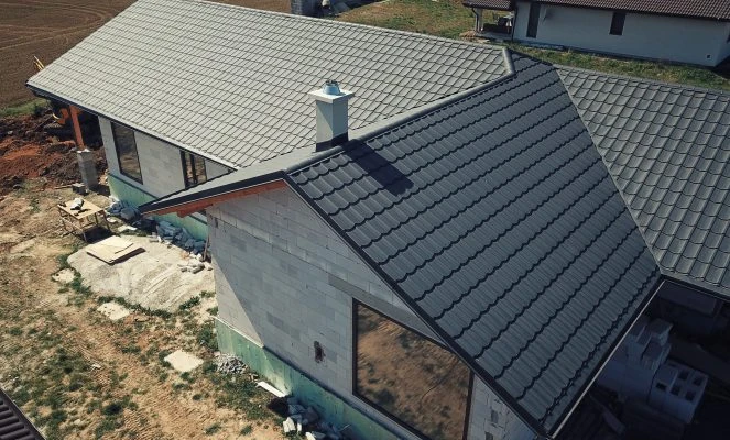Montáž oplechování střechy s závětrnými lištami na domě v budově