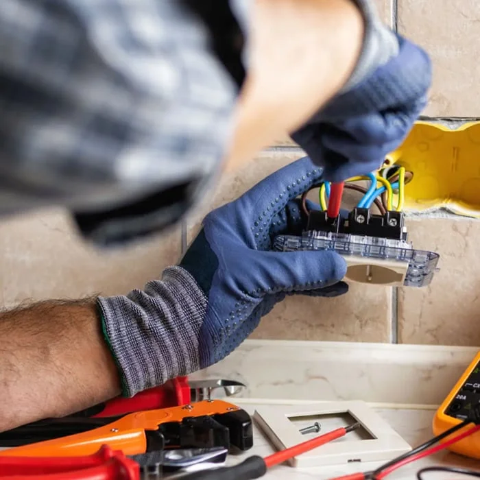 Elektrikář pracuje na instalaci elektrického zapojení s nástroji.