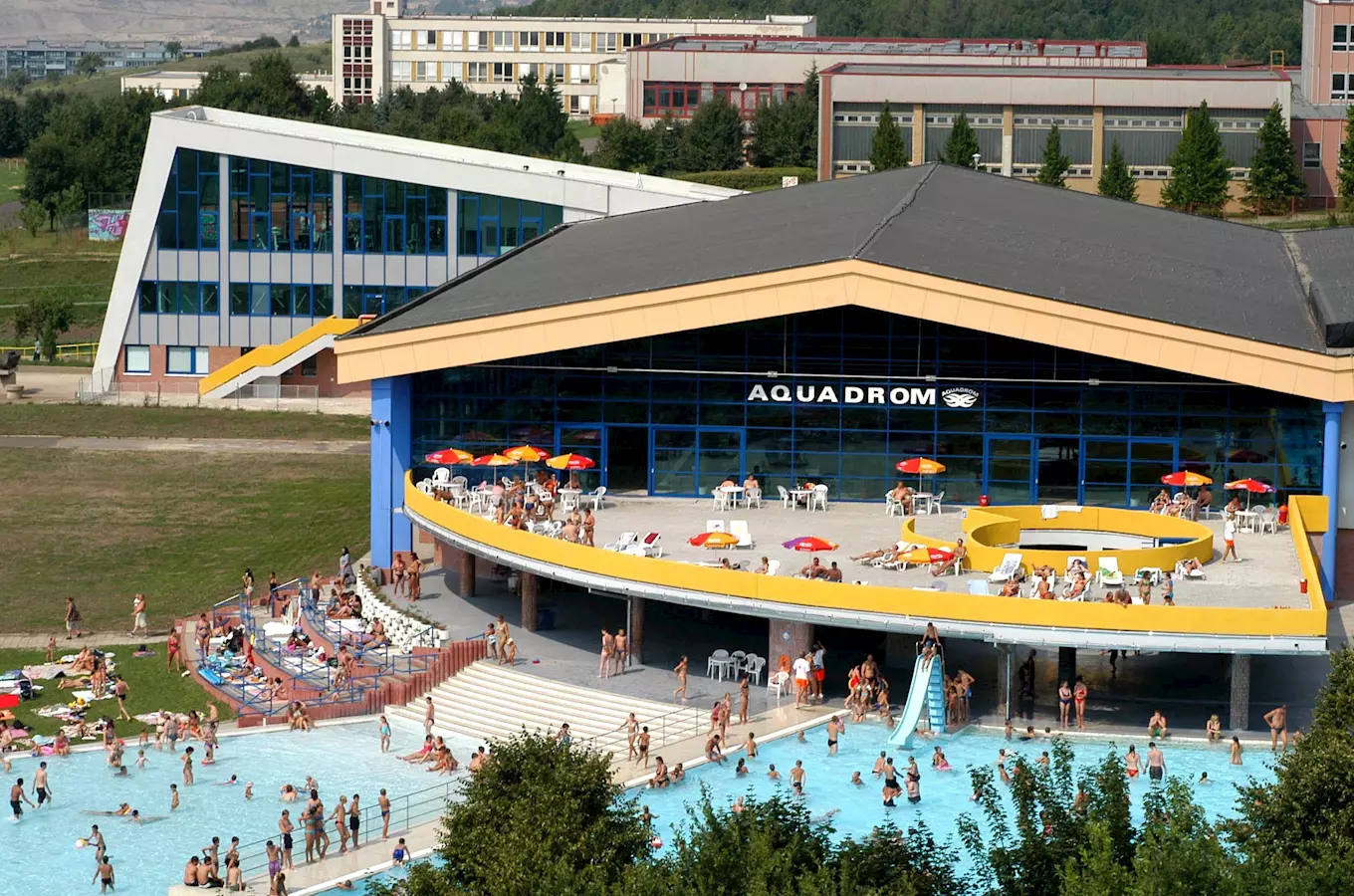 Venkovní bazén v koupališti Aquadrom v Mostě s lidmi.