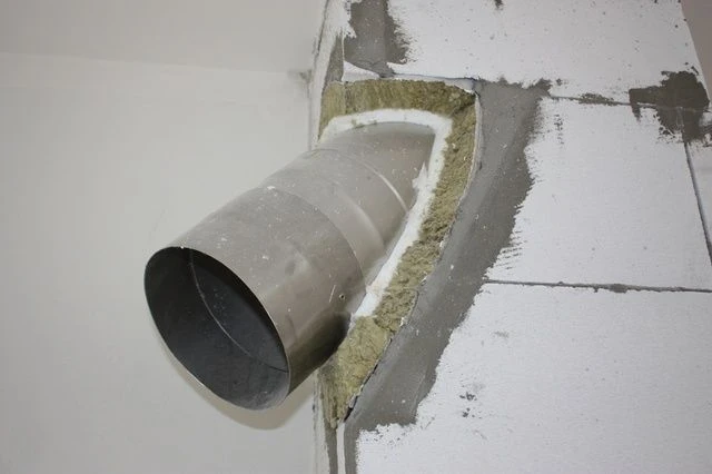 Instalace vložky do komína s izolací ve zdi.