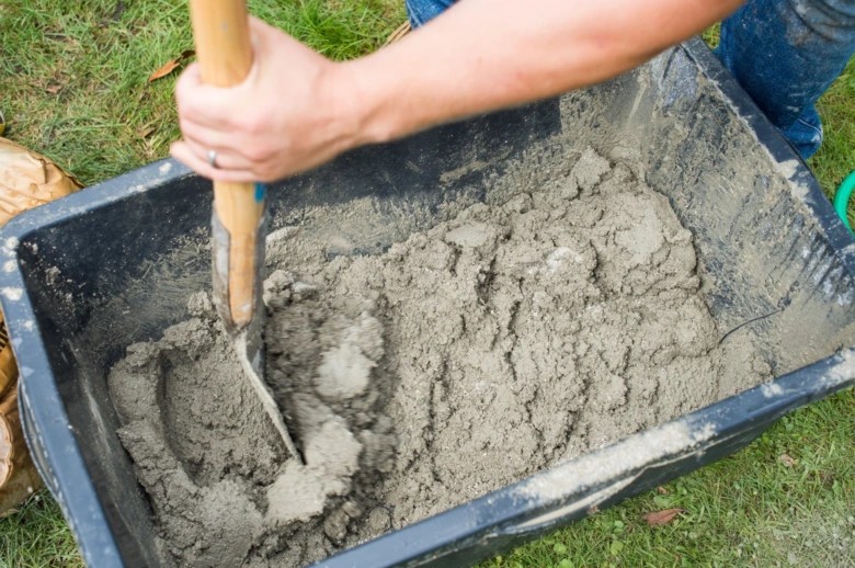Míchání suché betonové směsi lopatou v vozíku.