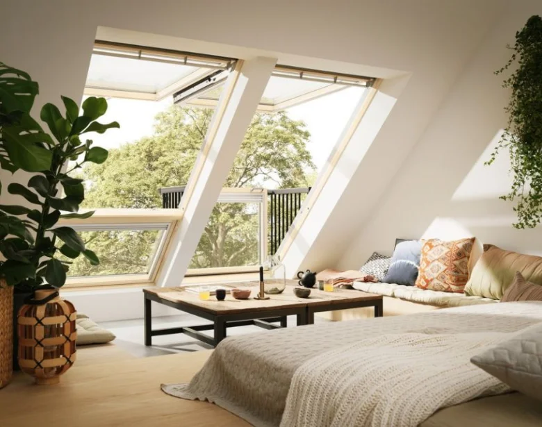 Loft s velkými střešními okny vedoucí na balkon.