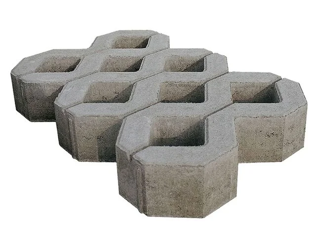 Světlé betonové dlaždice s propojeným vzorem pro venkovní použití.