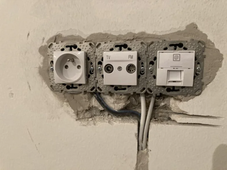 Instalace elektrických zásuvek v rekonstrukci bytu s viditelným vedením.