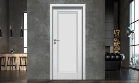 Bílá interiérová dveře v moderním prostoru s betonovou stěnou.