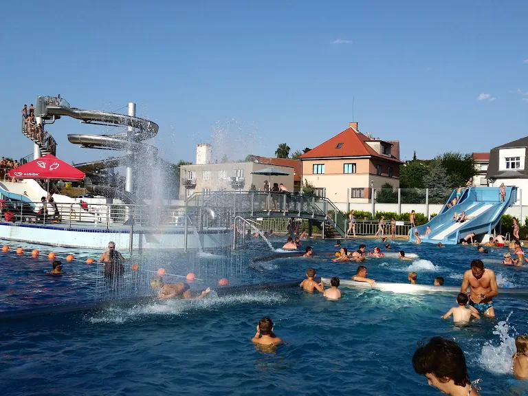 Venkovní bazén s vodními skluzavkami a plavci v Nové Pace.