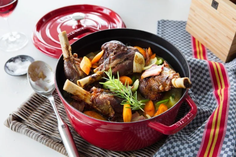 Red enameled cast iron pot with food inside