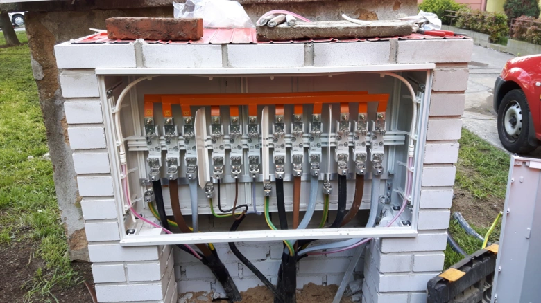 Otevřená skříň s elektrickými vodiči a svorkami v instalaci.