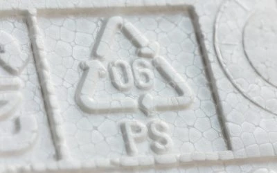 Zvětšený detail na recyklačním symbolu pro styren v budovách.