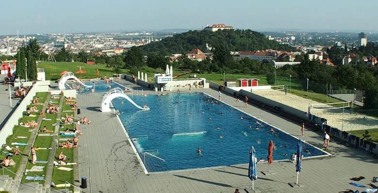 Venkovní bazén na kopci s plaveckými dálnicemi a skluzavkami.