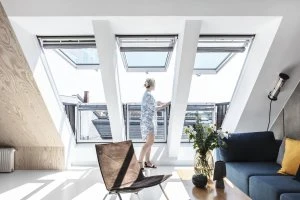 Střešní okno s přístupem na balkon v moderním interiéru.