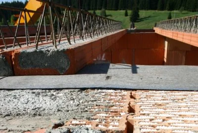 Stavební místo ocelového mostu s betonovými nosníky a kovovým zábradlím.