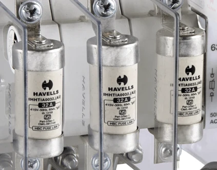 Tři pojistky značky Havells v držáku pro elektrické sítě.