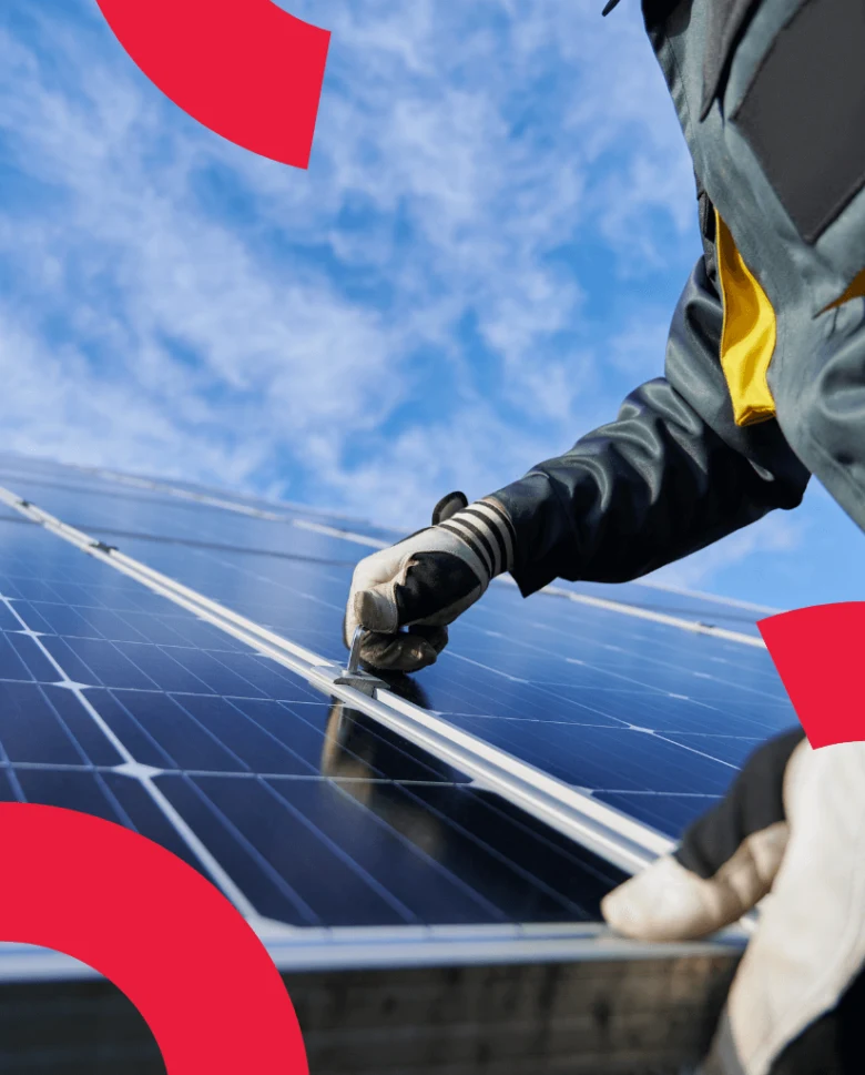 Montáž fotovoltaického panelu pracovníkem na střeše domu.