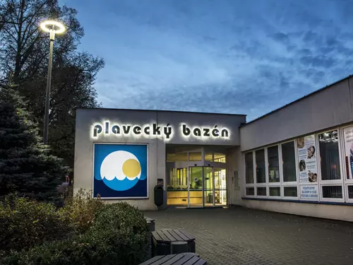 Vstup do plaveckého bazénu s osvětleným nápisem v Pardubicích.