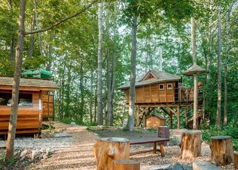 Dřevěný domek na stromech v lesu pro ubytování turistů.