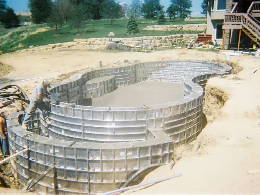 Práce s betonem při stavbě základů domu nebo bazénu.