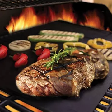 Grilovaný steak s zeleninou na ploché grilu nad plameny.