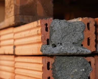 Detailní pohled na maltu mezi cihlami při zdění.