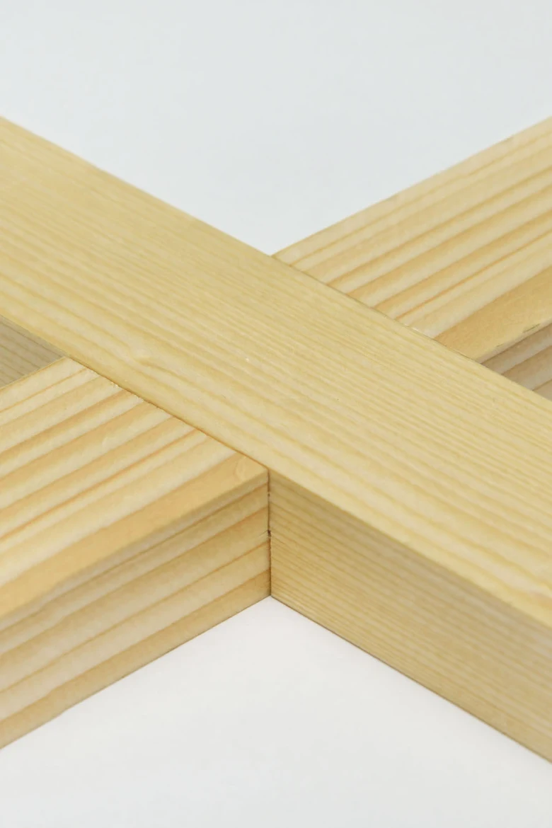 Detail dřevěného spoje v rohu konstrukce z přírodního dřeva.