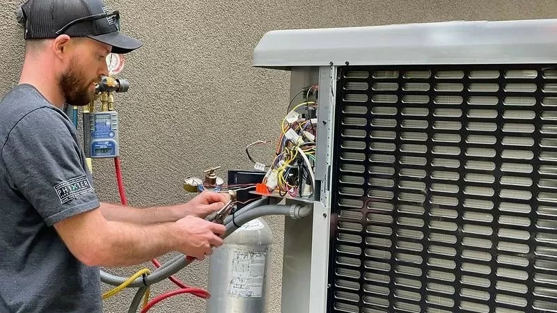 Technik opravuje venkovní jednotku pro ohřev vody v bazénu.