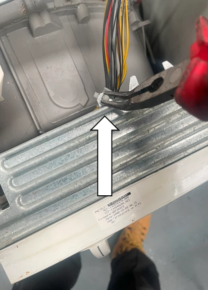 Odpojování elektrického konektoru uvnitř pračky při výměně hadice.