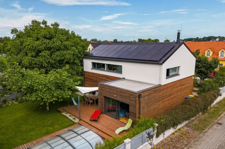 Modern dřevostavba s fotovoltaickými panely na střeše.